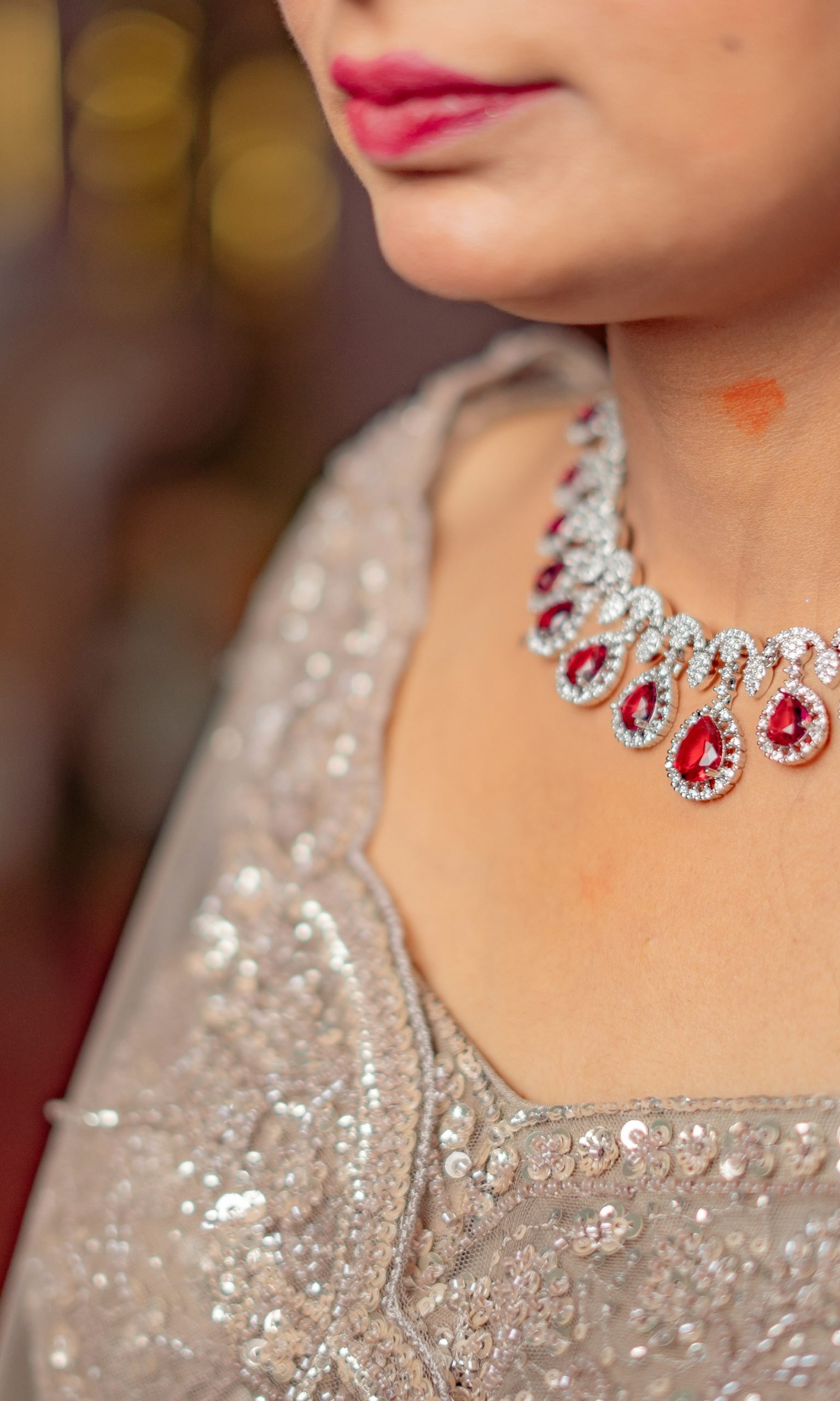 Woman wearing a diamond and ruby necklace with matching earrings