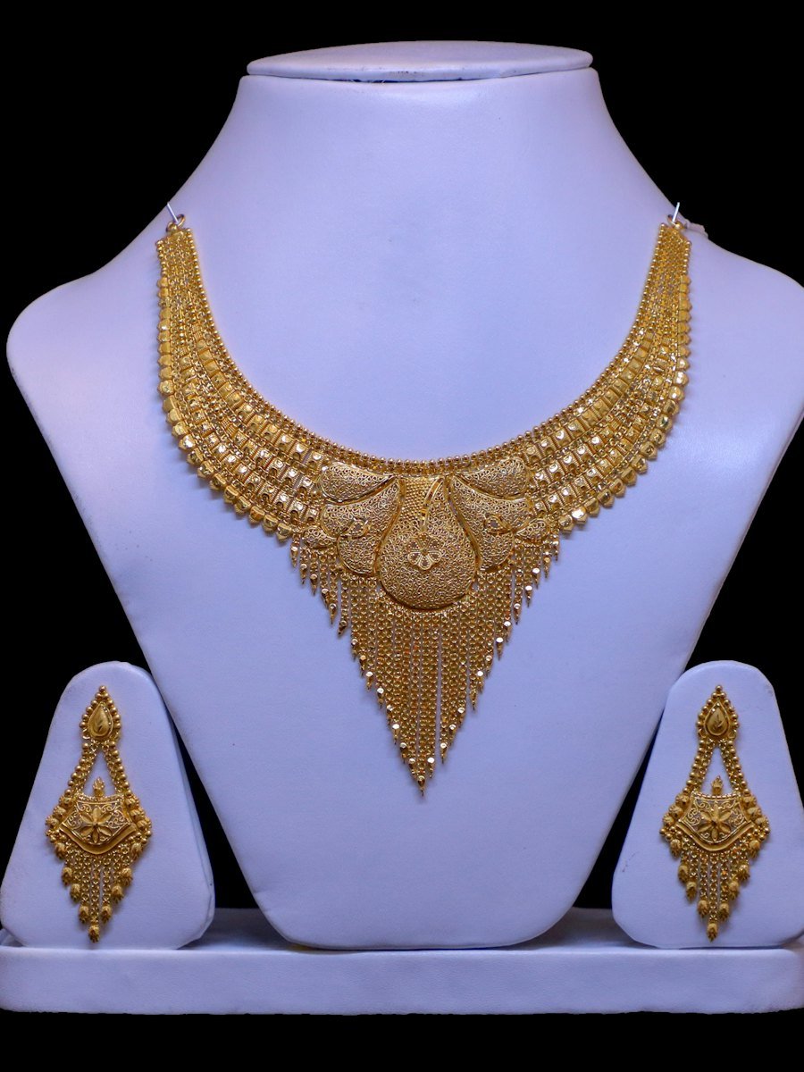 Gold bridal necklace and earring set on display stands