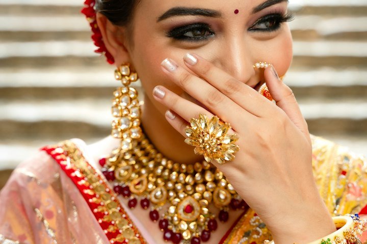 Bride in a yellow and red bridal outfit with gold jewelry
