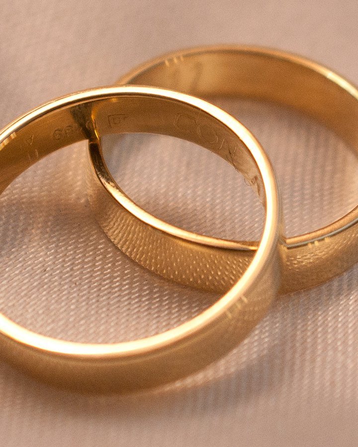 Two interlocking gold wedding bands on cream fabric