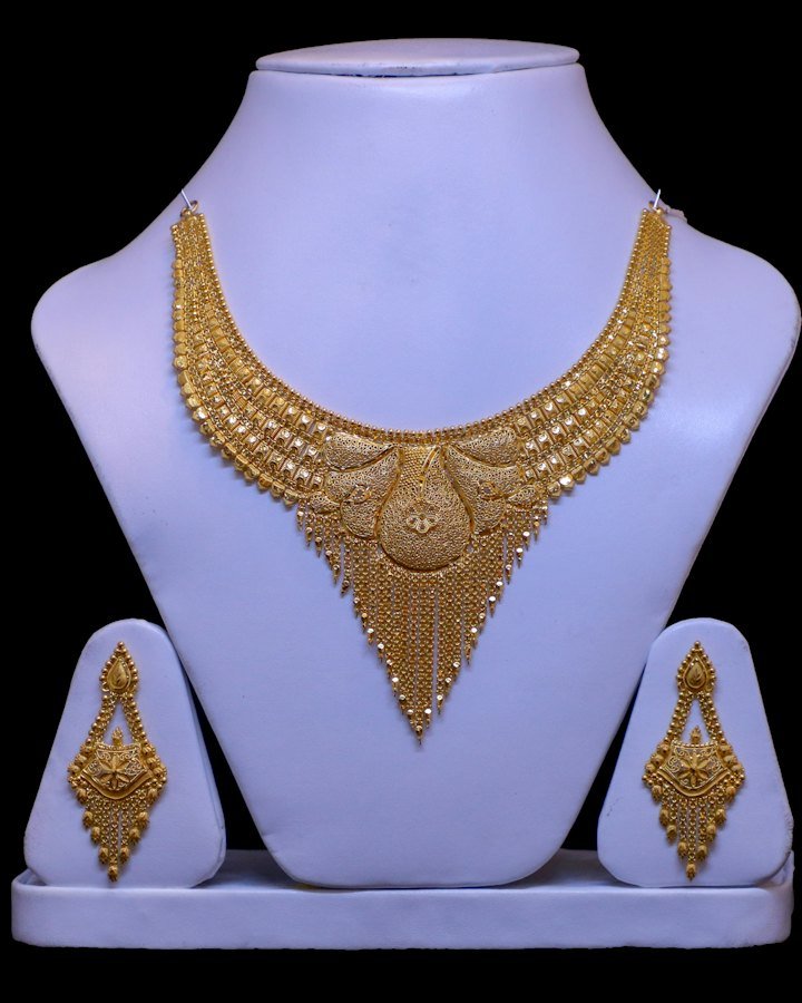 Gold bridal necklace and earring set on display stands