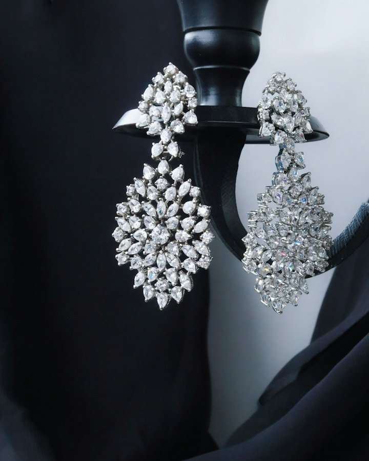 Diamond chandelier earrings on a dark decorative stand
