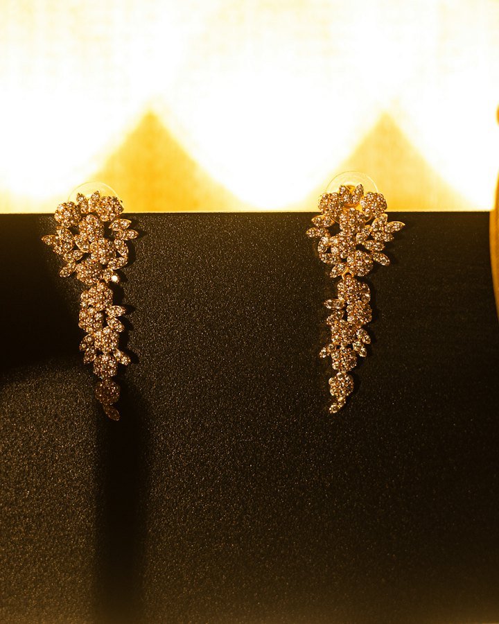 Sparkling diamond drop earrings on a black stand