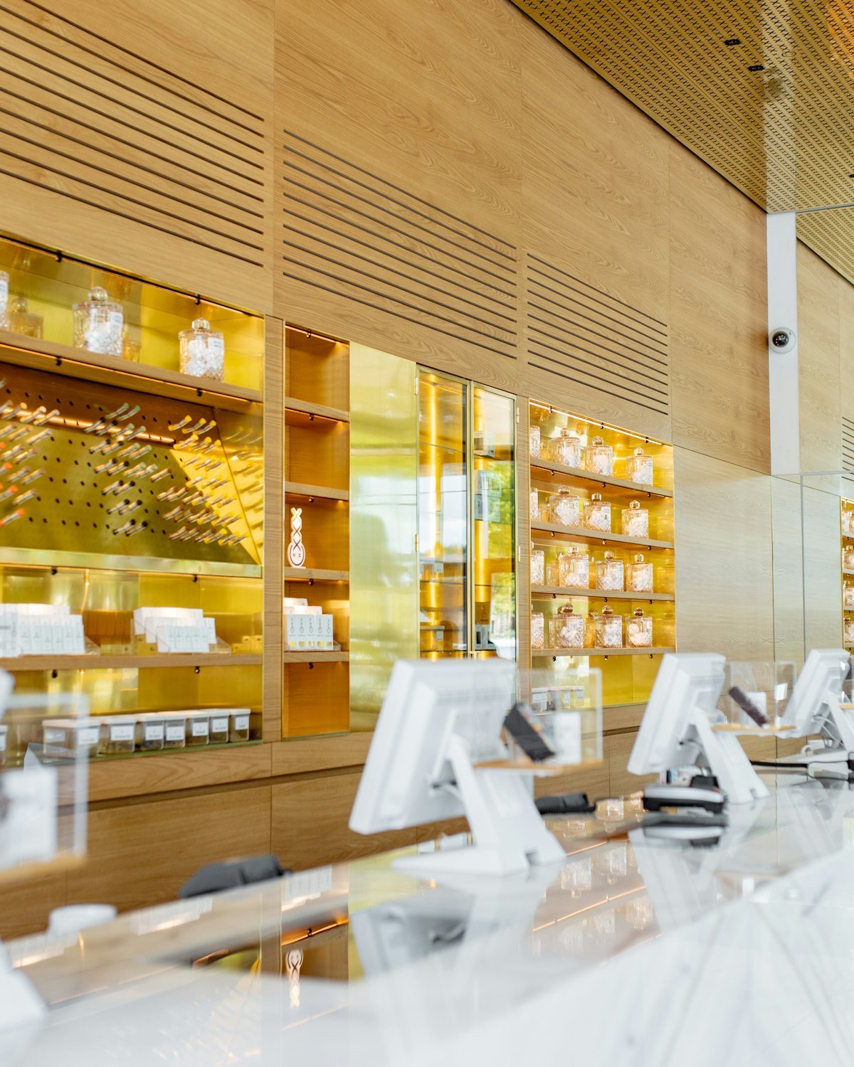 Bright jewelry showroom with white display counters and gold-lit shelves